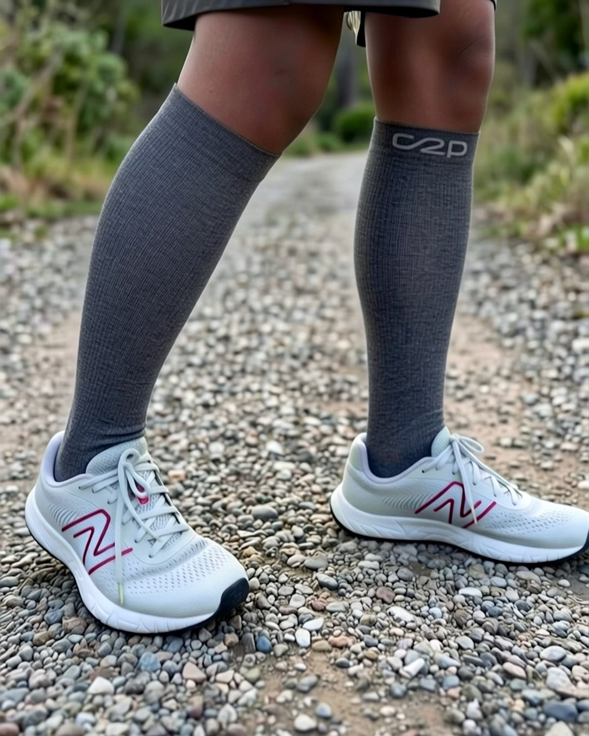 Dark grey merino knee-high compression socks with trainers on a walking path